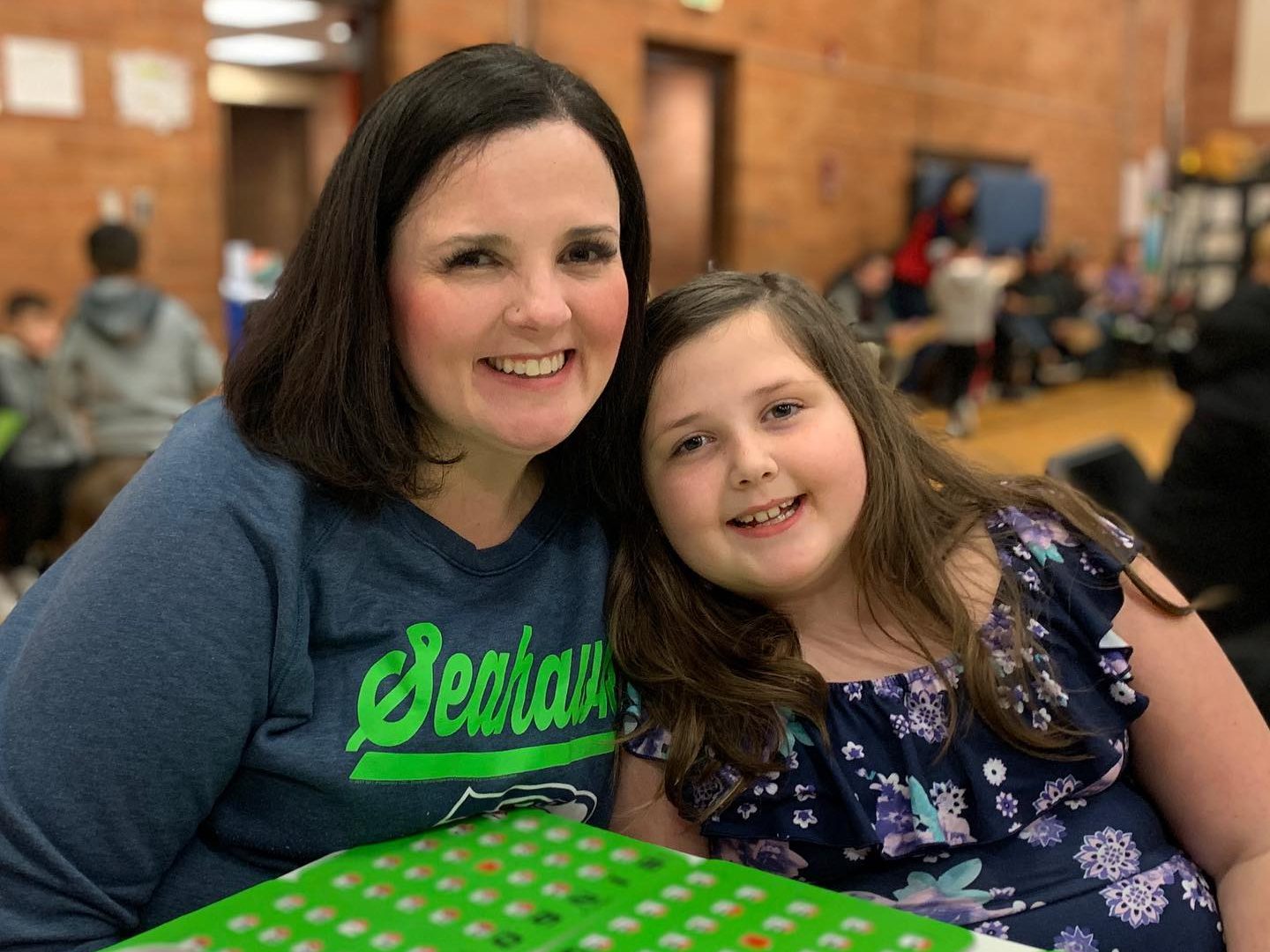 Mother and daughter at elementary school bingo night smiling
